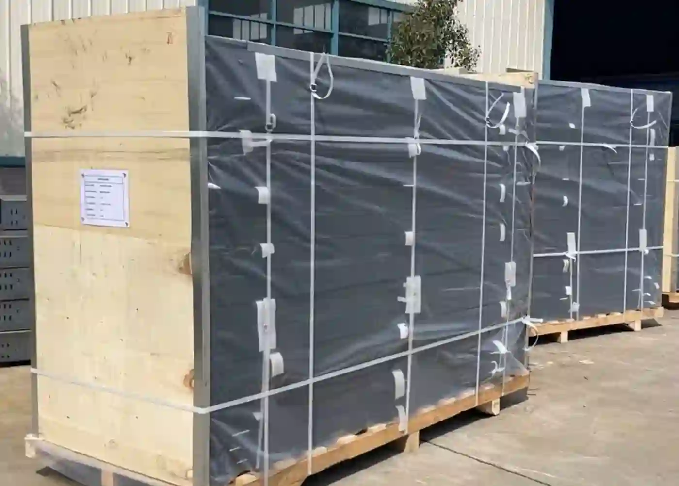 Cable tray packed in grey-wrapped crates on wooden pallets in the factory
